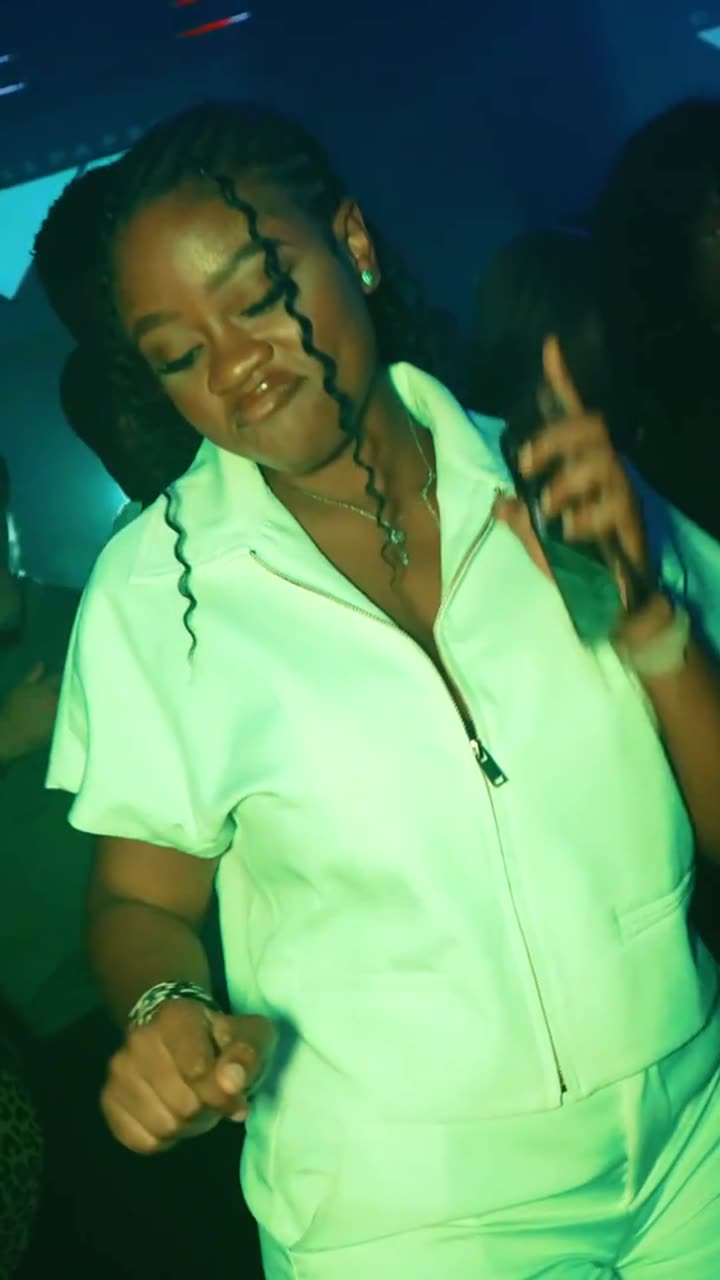 A woman dancing in a white two-piece outfit at G+